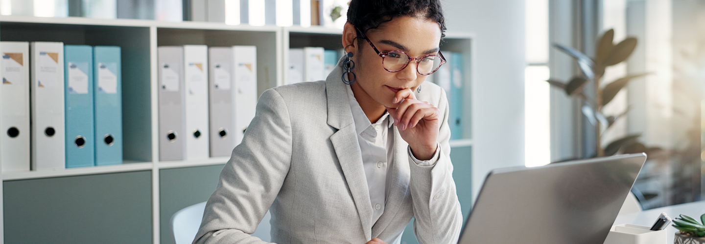 A woman working in a office concentrating on her laptop