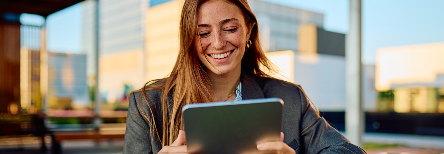 A woman sat on a tablet smiling outside