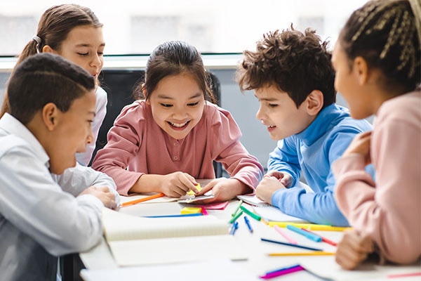 group of happy children working together in a classroom