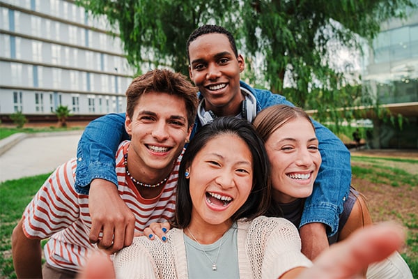 A group of four teenage friends laugh together