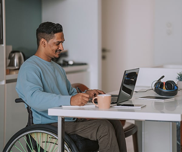 Man in wheelchair working on laptop