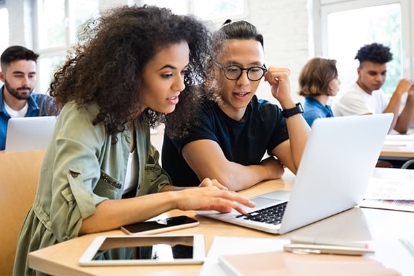 students work together on laptop