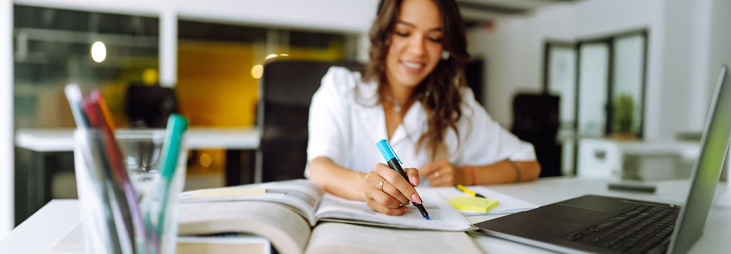 woman uses highlighter on book