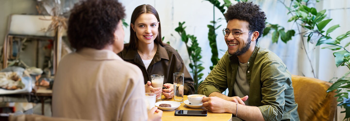 Three friends hanging out at a cafe, chatting.