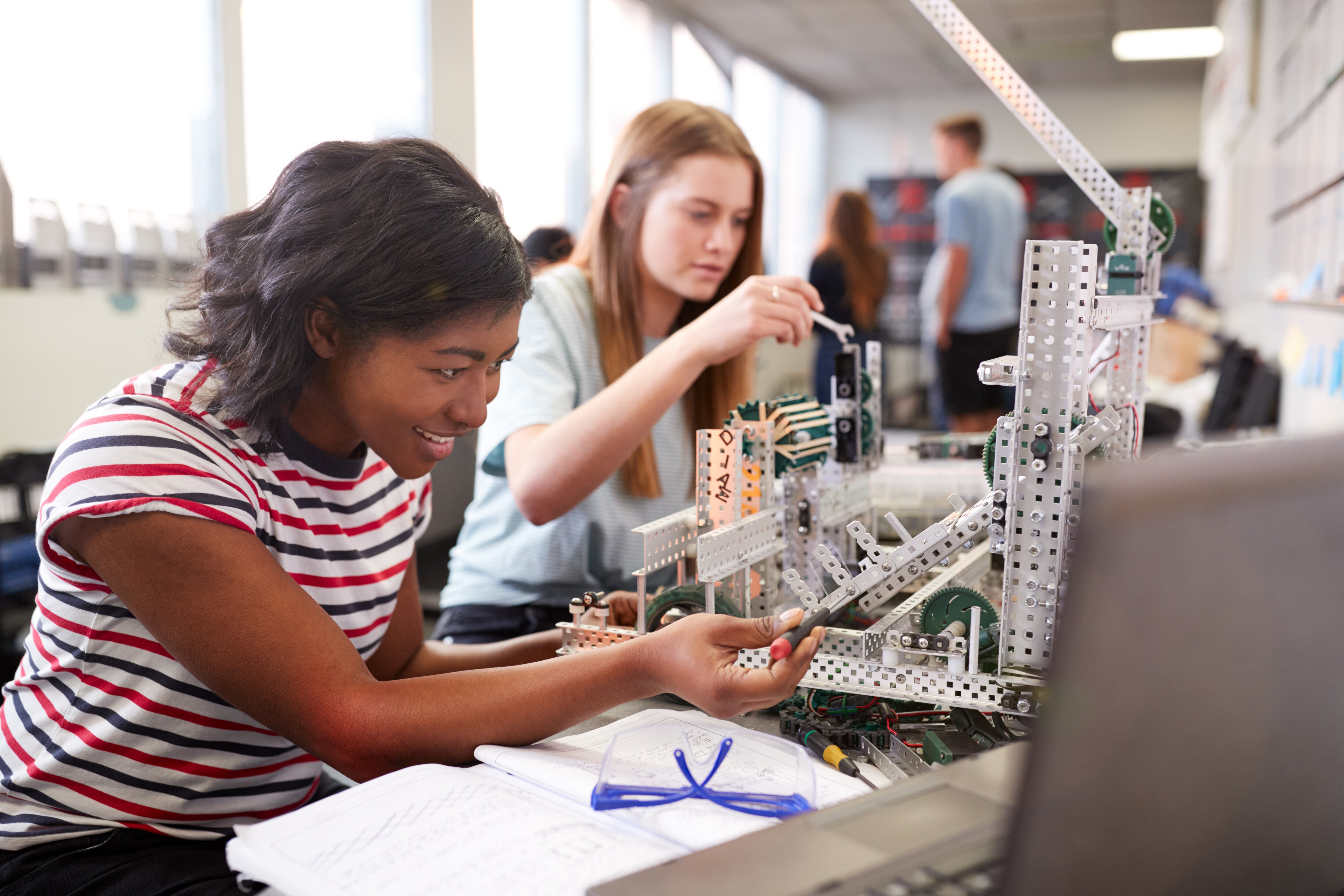 An image of a girl creating a robot in her engineering class