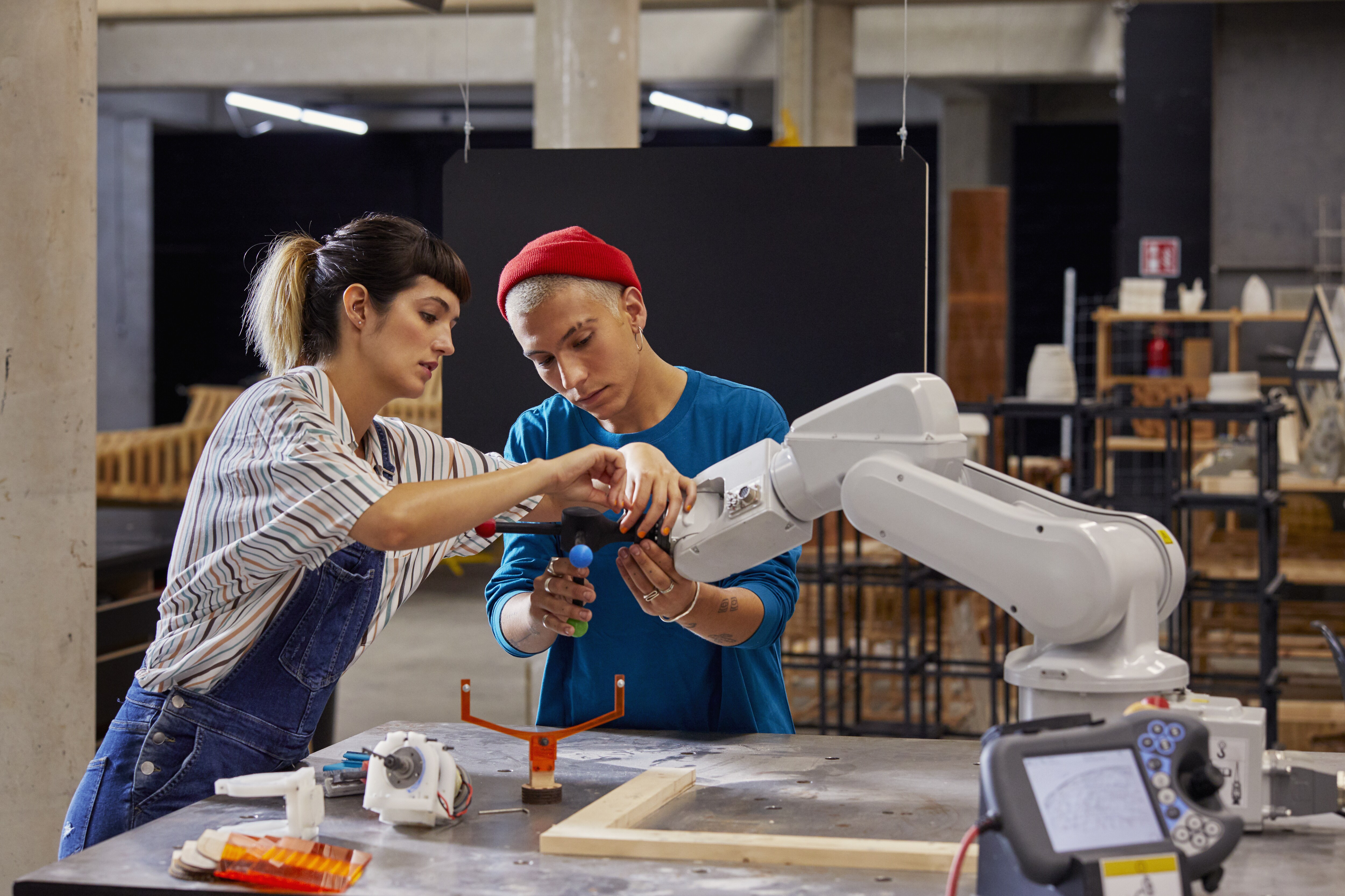 Photograph of two students working with a robotic arm